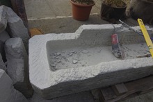 brunnen: Brunnentrog während der Restaurierung , Vierungen werden gehauen,risse werden aufgefrässt e.c.a